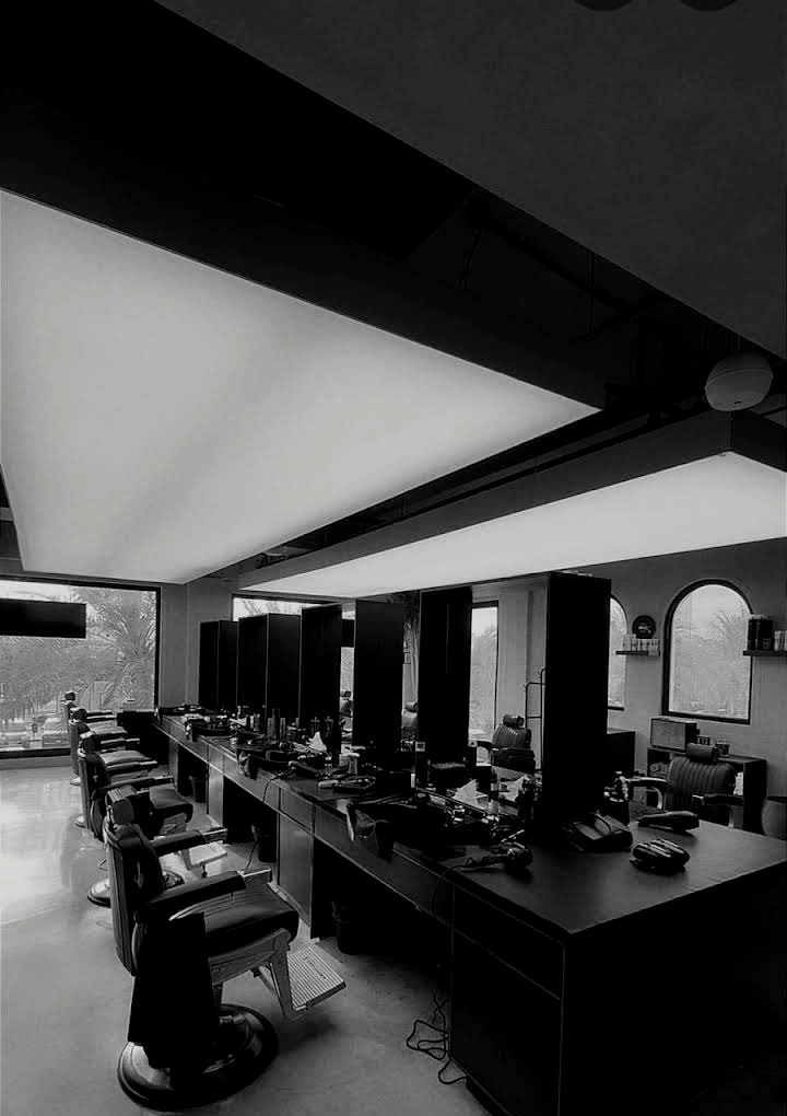 Chops Barbers interior — dramatic angular ceiling lighting over the barber stations